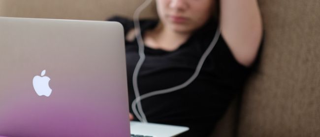 Teenager studying on apple laptop.
