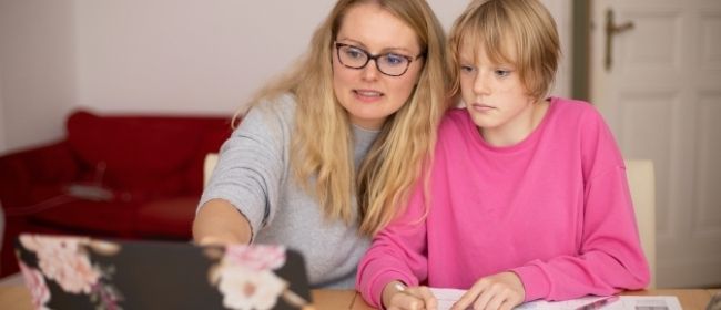 Woman and child looking at laptop screen.