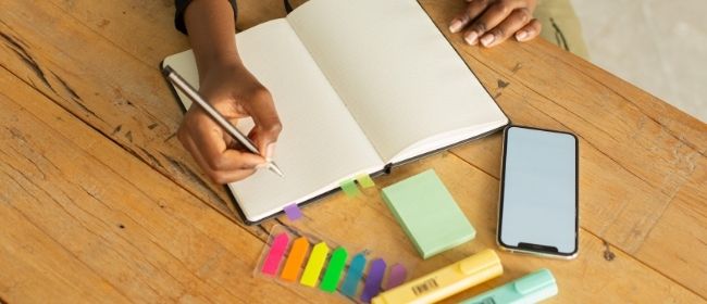 Girl taking notes in open notebook.