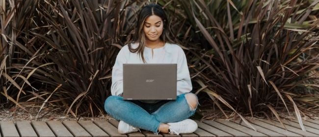 Girl sitting cross legged looking at laptop