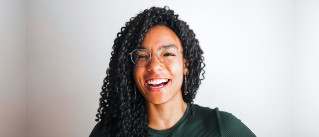 Young woman with glasses smiling.